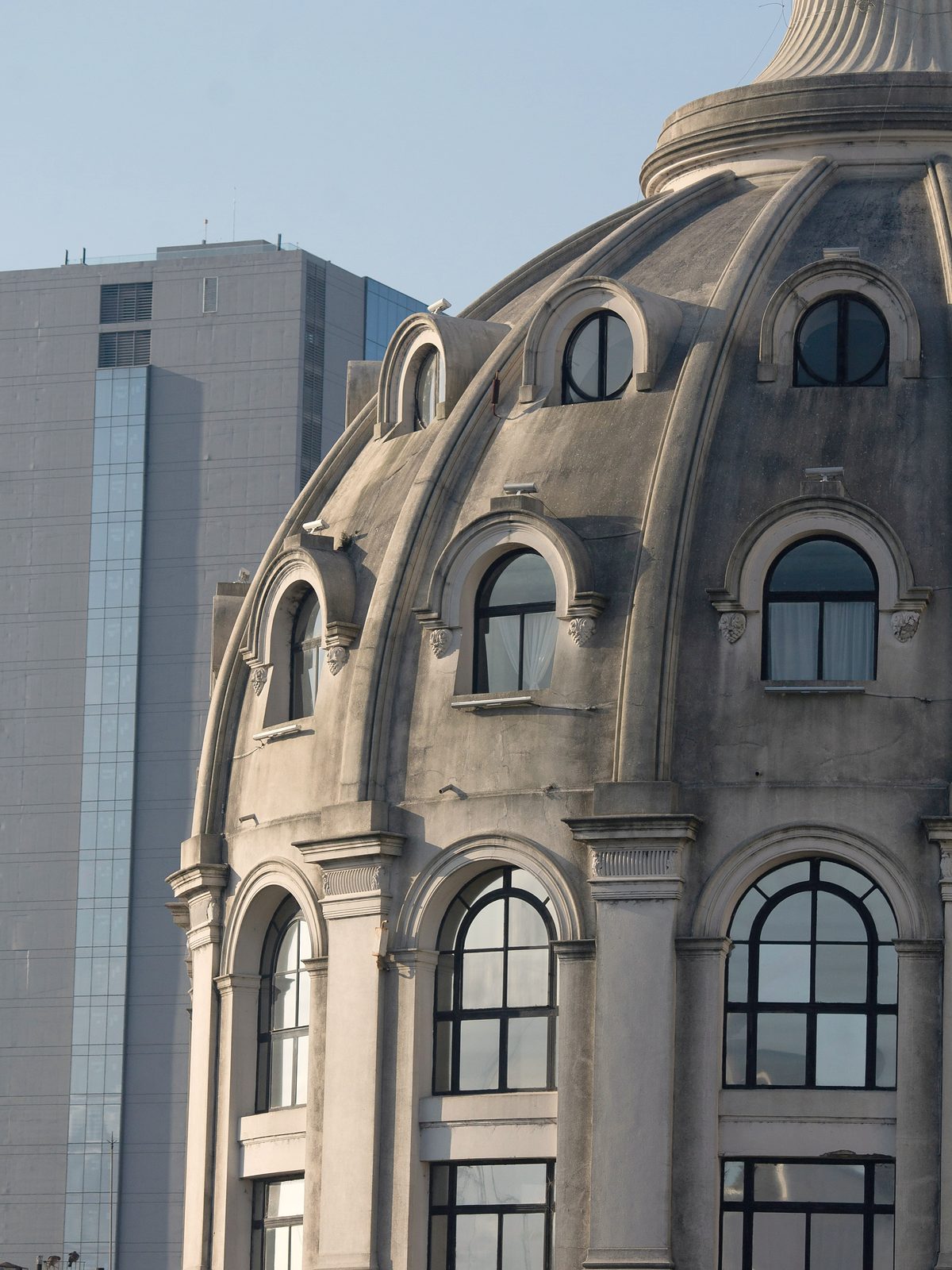 Cúpula de un edificio histórico porteño frente a una torre de vidrio contemporánea