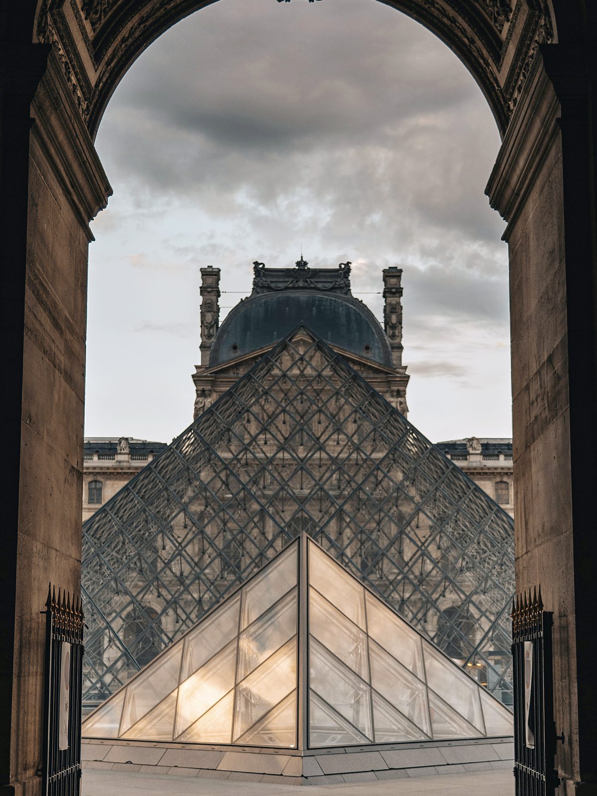 La pirámide del Louvre vista a través de un arco de piedra del palacio